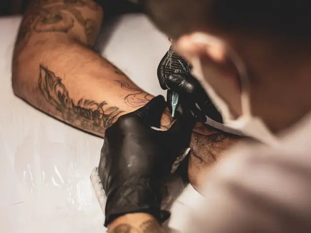 Tatuador trabalhando no braço de um cliente